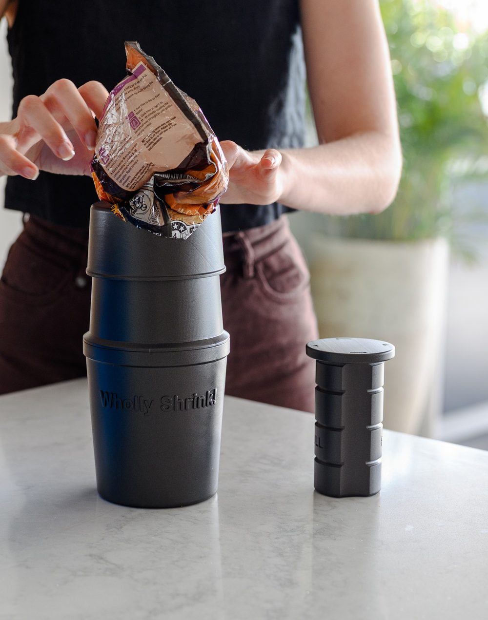 やわらかいプラスチック包装をThe Shrinker!に押し込んで圧縮する様子